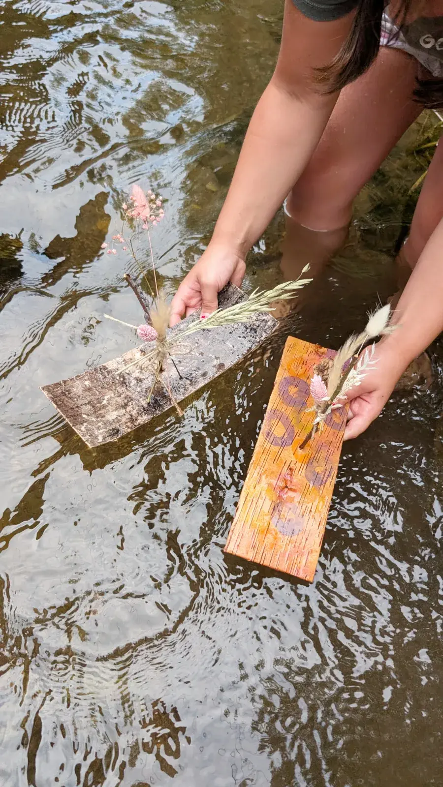 Handmade wishboats made from natural materials floating gently on water.