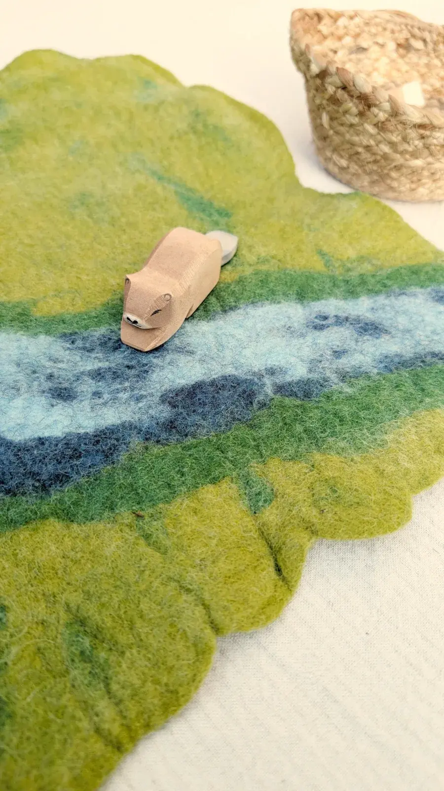 Handmade felt Riverbend playmat with a winding river, natural details, and space for small-world storytelling play.