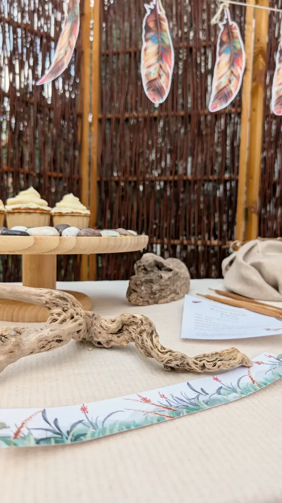 River-themed children's party setup with duck decorations, river pebbles, reeds, feathers, and nature-inspired party details.